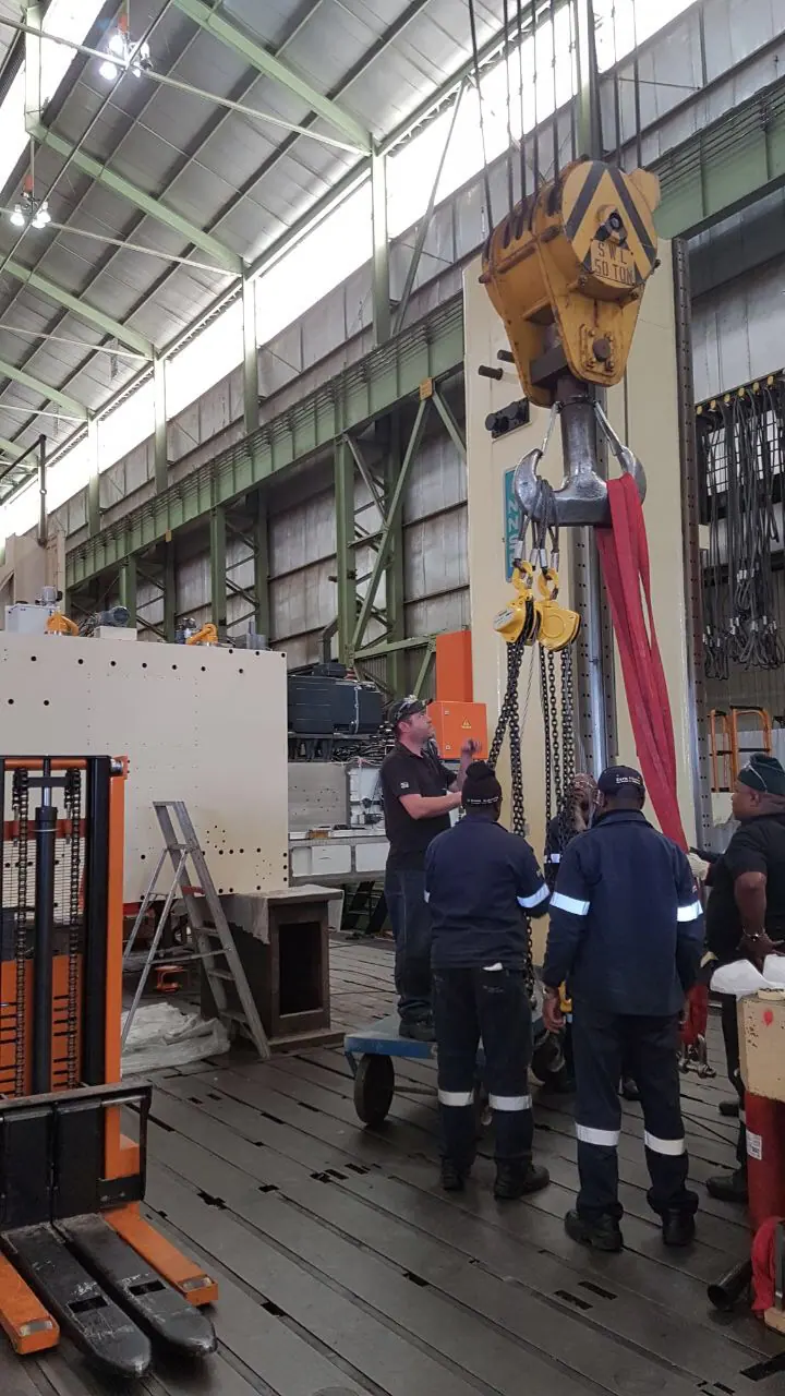Installation team working beneath a heavy overhead crane